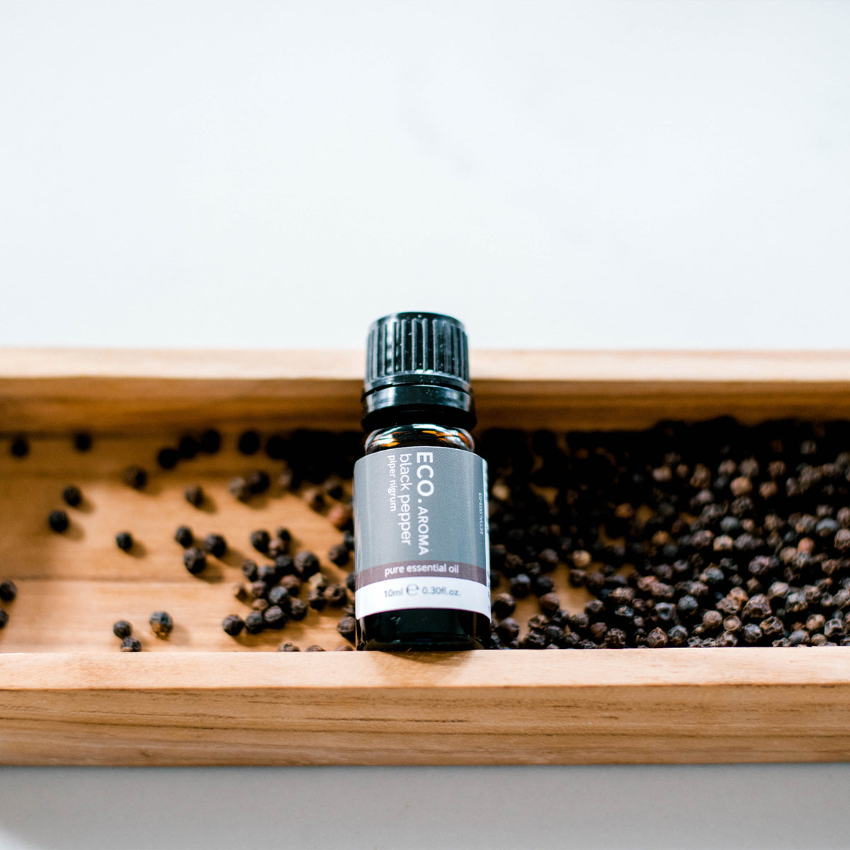 Black pepper aromatherapy oil and peppercorns 