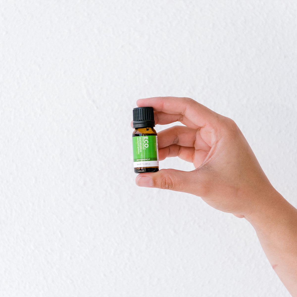 Hand holding eucalyptus essential oil bottle